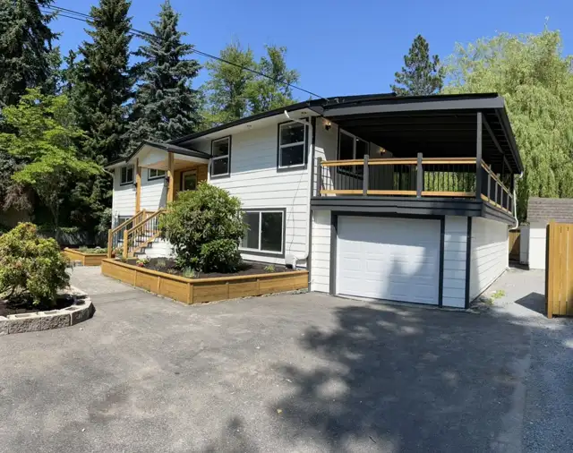 A renovated split-level home with a covered deck over the garage